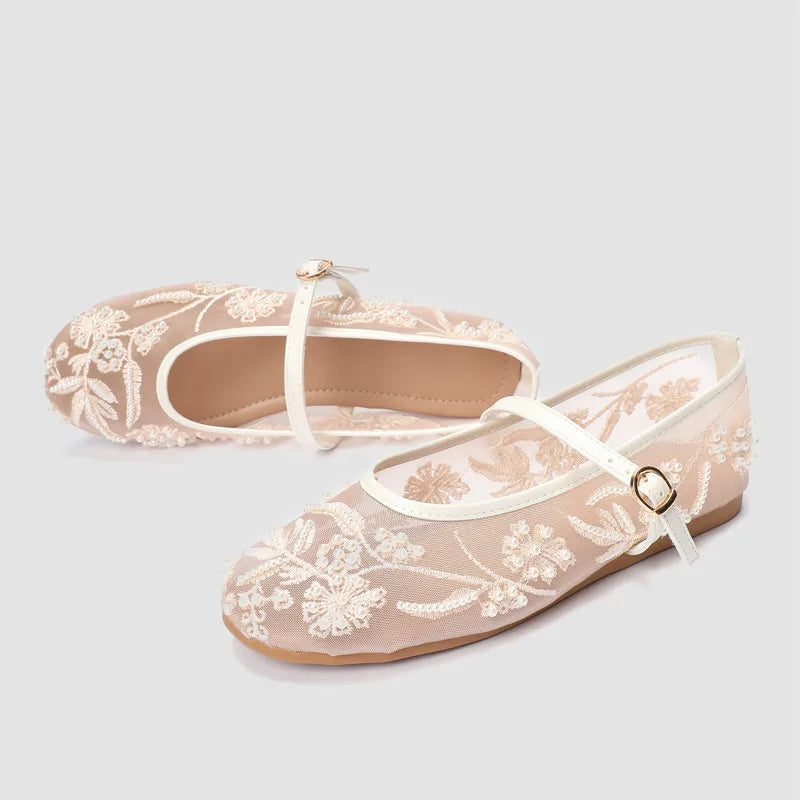 Pair of elegant ballet flats in beige with intricate floral embroidery and pearls.