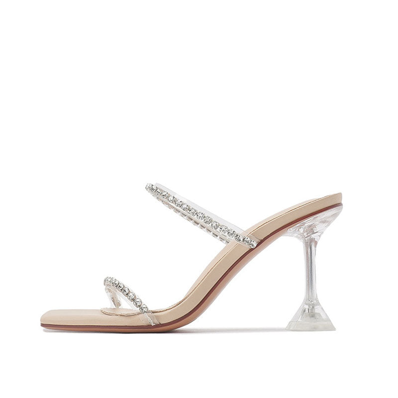 A pair of chic crystal embellished clear PVC square toe mules with apricot insole and silver footbed, featuring a dual-footstrap with plexiglass construction and a backless heel design.