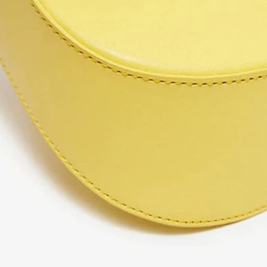 Yellow handbag with visible stitching on a white background