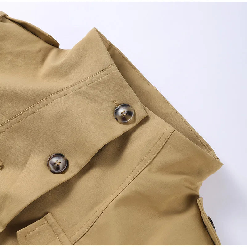 Close-up of a beige trench coat with buttons on a white background