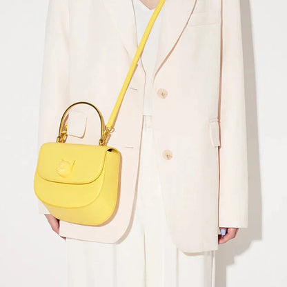 Person holding a yellow handbag against a white background