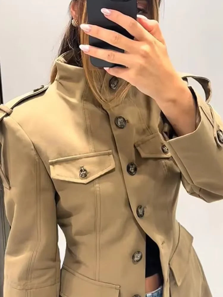 Beige trench coat worn by a person, with a neutral background