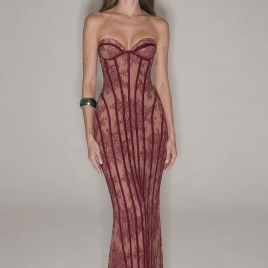 Red strapless lace corset maxi dress shown from the side with fitted bodycon shape and sheer lace eveningwear