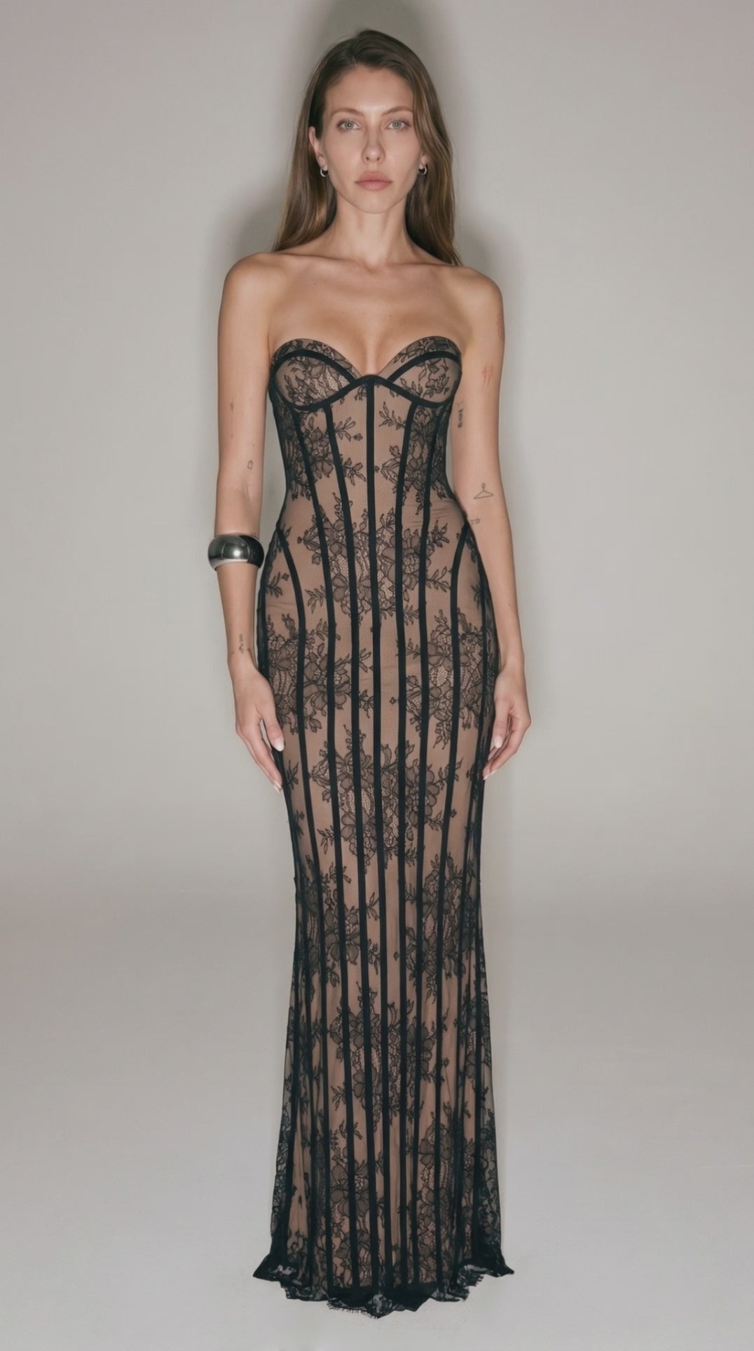Black sheer lace corset maxi dress with strapless neckline, bodycon fit, and see-through floral lace design for evening